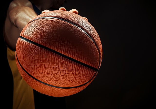 silhouette_view_of_a_basketball_player_holding_basket_ball_on_black_background