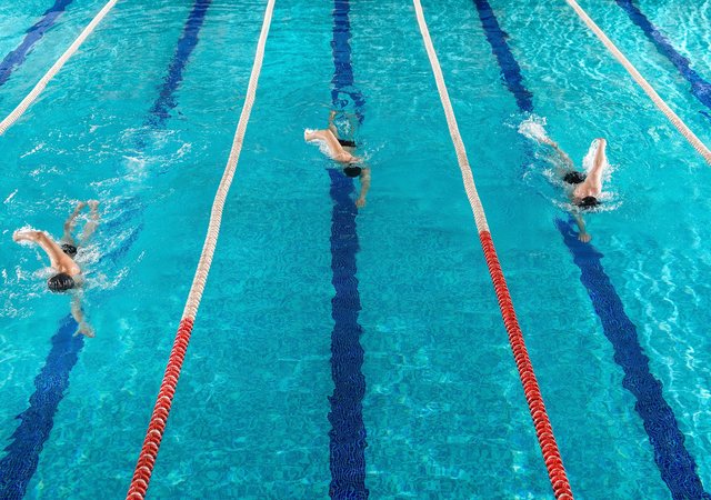 three_male_swimmers_racing_against_each_other